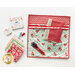 A colorful fabric organizer featuring various patterned fabric squares in red, green, and white, along with a rotary cutter, spools of thread, and a ruler, arranged neatly with the logo of Shabby Fabrics visible in the corner.