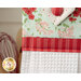 Close up photo of a hanging kitchen towel made with red, white and aqua fabrics in the foreground of a shelf filled with kitchen items like cooking utensils.