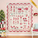 The completed quilt in cream, red, and pale teal blue, hung on a pink paneled wall and staged with coordinating furniture. A golden banner reads 