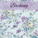 A light blue fabric with large sprawling shabby florals in blue, cream, and wisteria purple. A purple banner at the top reads, 