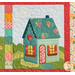 Close up of one block from the "Welcome Home in Spring" quilt showing a teal house from a three quarters angle.