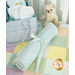 The completed Changing Pad, staged in a crib with mint green sheets, rolled up and neatly tied.