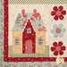 A close up on one of the blocks, showing fabric and stitching detail on a multicolor cottage, bordered by laser cut flowers.