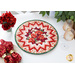 A shot of the completed Point of View Folded Star Table Topper in bright red, pink, white, and green fabrics from the Poppy Hill collection. The Topper is staged on a white table with red roses, red cloth napkins, wine glasses, and a ficus.