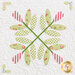 Close up on a block featuring applique details on criss crossing leaves with red striped blooms.
