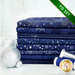 A photograph of the stacked fat quarters included in the Dark Blue/Silver set, staged with blue and silver thread and silver ornaments.