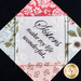 A decorative fabric piece with a central quote that reads, Sisters make my life wonderful, surrounded by floral-patterned fabric in soft colors.