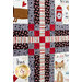 A colorful quilt featuring a variety of patterns and images related to dogs, including playful text, hearts, and illustrations of dogs and dog-related items like a fire hydrant. The quilt has a prominent cross pattern made from strips of fabric in red, gray, and black.