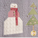 A super close up on a block with a snowman and a Christmas tree, demonstrating piecing, top stitching, and embellishment details. 