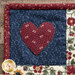 A super close up on one of the corner heart blocks, demonstrating fabric and stitching details on the applique heart.