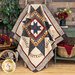 A wide shot of the quilt, artfully draped over a rustic ladder. The quilt is staged with coordinating furniture and decor. 