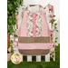 The completed pink Clothing Coverall, colored in baby pink, chocolate brown, and floral white. The coverall is staged on a white picket fence with matching pink roses and a leafy houseplant.