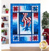 The completed Patriot Panel Quilt in vibrant red, white, and blue fabrics, hung on a white paneled wall and staged with coordinating furniture and decor.