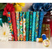 A stack of the fabrics in the Boho Blooms FQ set, with flowers and jars and thread.