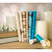 A stack of the Amazing Grace fabrics with candles and books and flowers and thread.