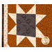 Close-up of a sawtooth star quilt block featuring orange and black fabrics with leaf and floral designs.