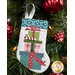 The completed Gifts stocking, hung on a green Christmas tree decorated with red bulbs.