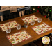 The four completed placemats staged on a wooden table with coordinating glassware and decor.