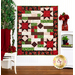 The completed Comfort of Psalms quilt in Vintage Rose, a collection of red, green, and cream floral fabrics. The quilt is hung on a white paneled wall and staged with coordinating furniture and decor, including red roses.