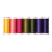 Seven spools of thread in yellow, pink, green, and purple, isolated on a white background.