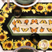 A top down shot of the table runner on a white table showing detail on the sunflower and butterfly fabrics and staged with coordinating plates and glassware. 