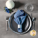 A top down shot of a place setting with the striped fabric of the reversible napkin faced out.