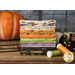 A stack of the fabrics from the Ghoul Friends collection, with pumpkins and books and a witch's shoe and thread.
