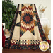 A colorful star-patterned quilt in earthy colors draped over a chair, surrounded by plants and decorative items.