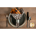 A top down shot of a place setting with the checkerboard fabric of the napkin faced out.