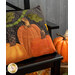 A close up on the right side of the pillow, demonstrating fabric and top quilting details, staged with coordinating fall decor. 