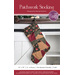 Patchwork Christmas stocking hanging on a mantel with a pine garland.