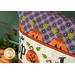 A closer look at the pillow, showing fabric colors and details on the applique jack-o'-lanterns that form the border.