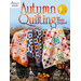 Front cover of the pattern, showing three autumn themed quilts draped over a stone wall outdoors on a fall day. 