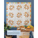 A lifestyle photograph of a pieced autumn leaf quilt.