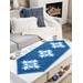 A shot of a wintry blue table runner, staged in a living room.