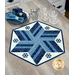 A hexagonal quilted table centerpiece project featuring winter colors and applique snowflakes, displayed on a gray table decorated in tableware.