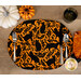 A top shot of the black cat oval placemat set with silverware, surrounded by coordinating Halloween decor.