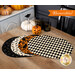 The four completed Oval Placemats colored in black, cream, and orange fabrics from the Hallow's Eve collection, showcasing the reversible design, and staged on a wooden table, surrounded by coordinating tableware and Halloween decor.