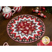 The completed Point of View Folded Star Table Topper, colored in red, black, and white. The topper is staged on a wooden table with coordinating holiday candy and mugs of hot cocoa.