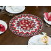 A shot of the completed table topper displayed on a wooden table set with white plates and coordinating cloth napkins and gold silverware.