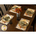 Table set with green napkins, golden plates, and decorative placemats, featuring a floral centerpiece.