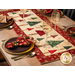 A closer look at the runner on a wood table, staged with color coordinated wine glasses and table ware.