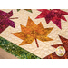 A super close up on the topper, demonstrating top quilting, patchwork leaves, and fabric print details.