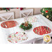 The four completed Oval Placemats colored in red and white fabrics from the Sugar Coated collection, staged on a white table in four place settings, surrounded by coordinating decor.