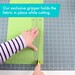 A hand using a rotary cutter on green fabric, with a ruler holding the fabric in place.