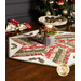 A angled shot of the table topper holding a festive candle with holly, surrounded by coordinating napkins and decor.