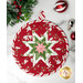 A red round quilted pot holder with a white, pink, and green star pattern displayed on a white marble counter while coordinating seasonal decor peeks into the right and left sides of the frame.