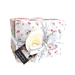 A neatly bundled set of fabric squares wrapped with a measuring tape ribbon, featuring festive patterns.