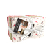 A neatly tied bundle of fabric squares with festive patterns and a tag featuring a woman’s image.