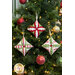 The three completed ornaments colored in red, white, and light green Christmas fabrics, hung on a decorated and lit tree.